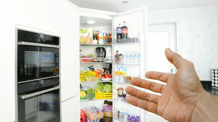 mano che indica frigorifero pieno