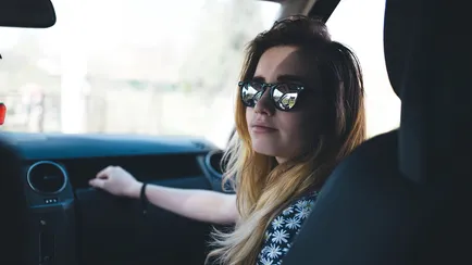 ragazza con occhiali da sole in auto