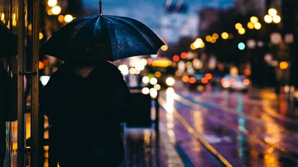 Persona con ombrello si protegge dalla pioggia del ciclone pulcinella
