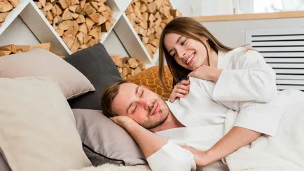 coppia dorme in camera con parete con legna