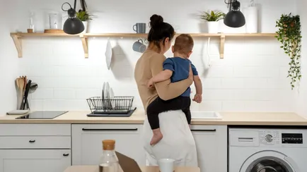 donna con bambino in braccio usa la cucina